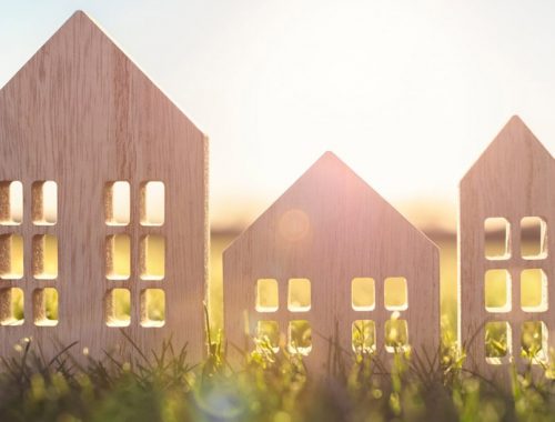 3 petites maisons en bois posées dans de l'herbe