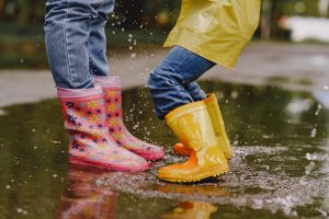 Bottes de pluie d'enfants sautant dans une flaque d'eau