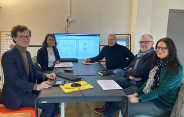hommes et femmes autour d'une table lors d'une réunion